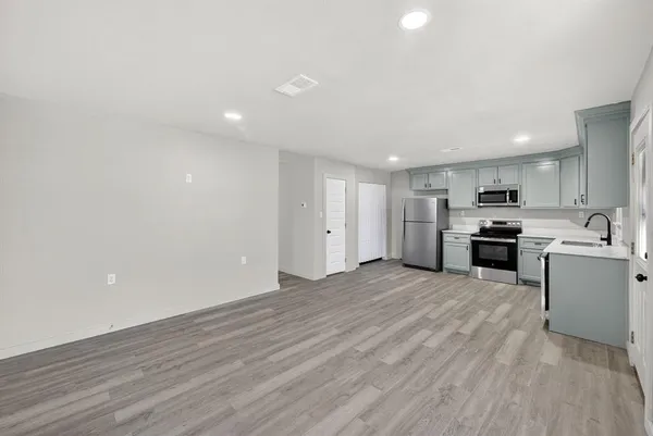 a view of kitchen with wooden floor and electronic appliances