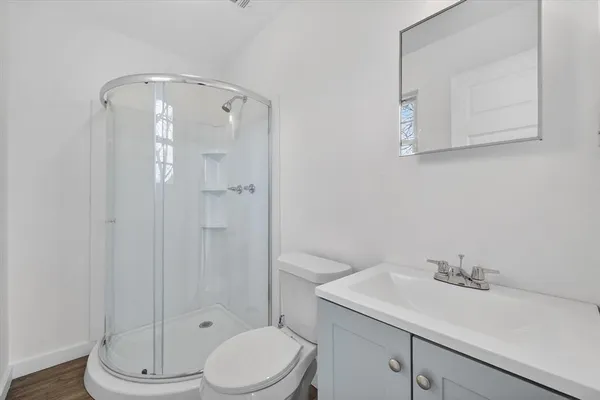 a bathroom with a sink a toilet and shower