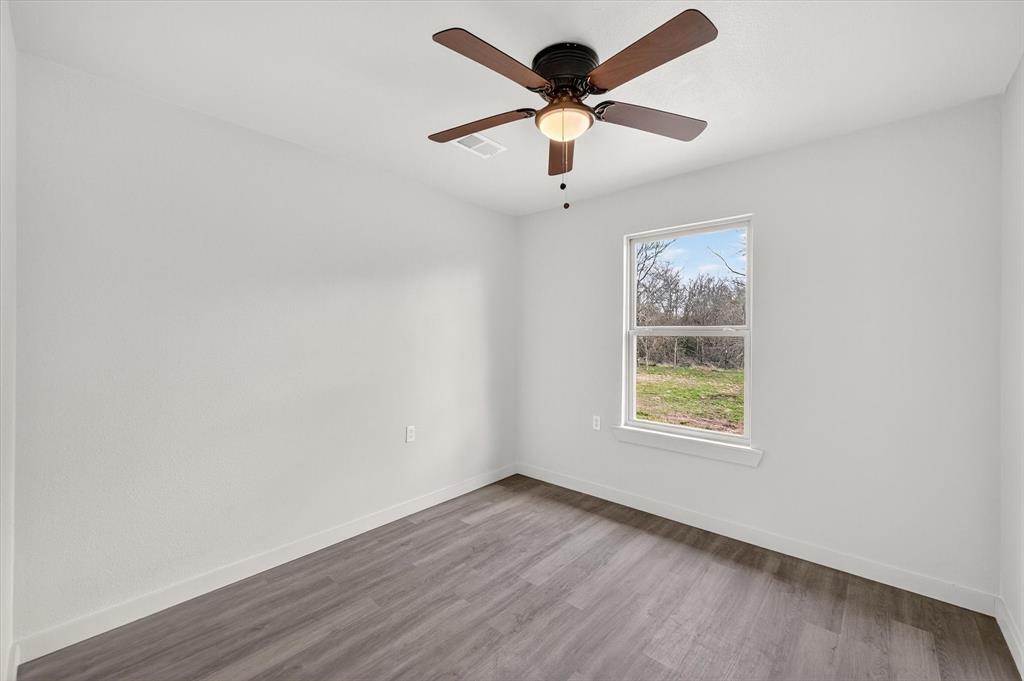 705 South 3rd Street East Dawson, TX 76639 - Photo 17 of 25 wooden floor in an empty room with a window