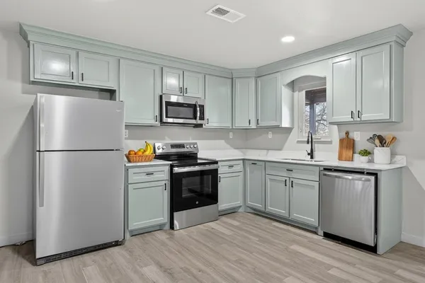 a kitchen with granite countertop a refrigerator stove top oven and sink