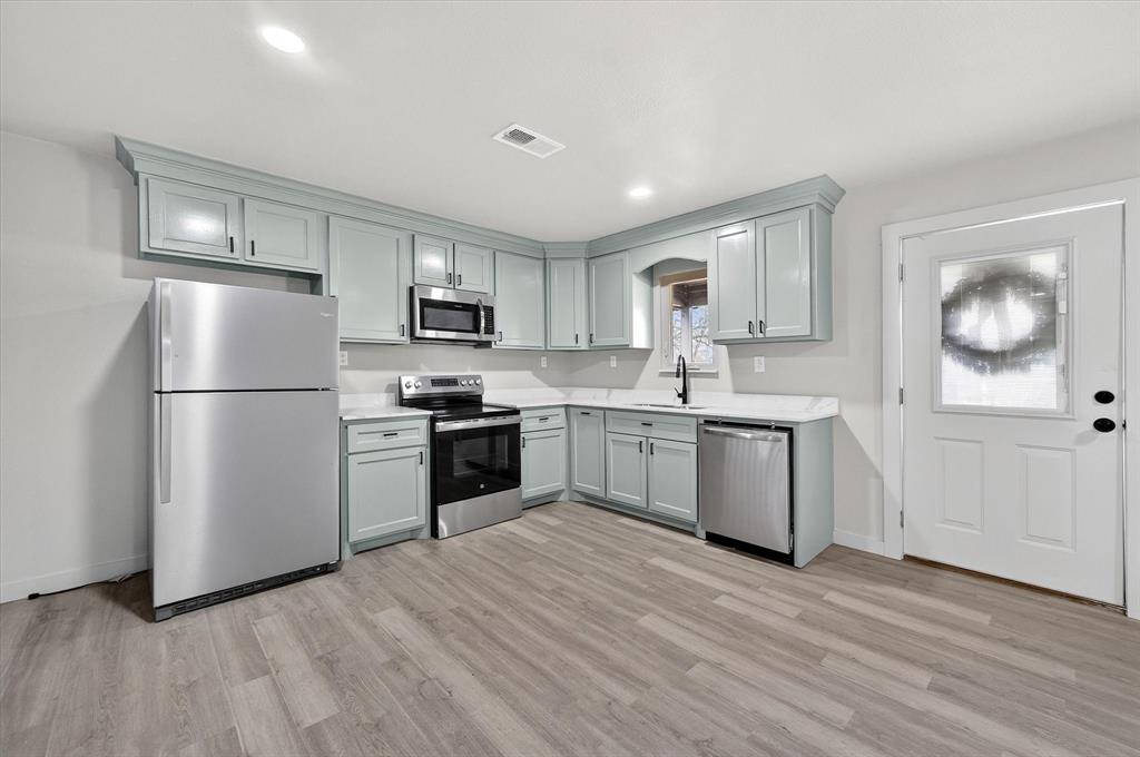 705 South 3rd Street East Dawson, TX 76639 - Photo 10 of 25 a kitchen with granite countertop white cabinets and stainless steel appliances