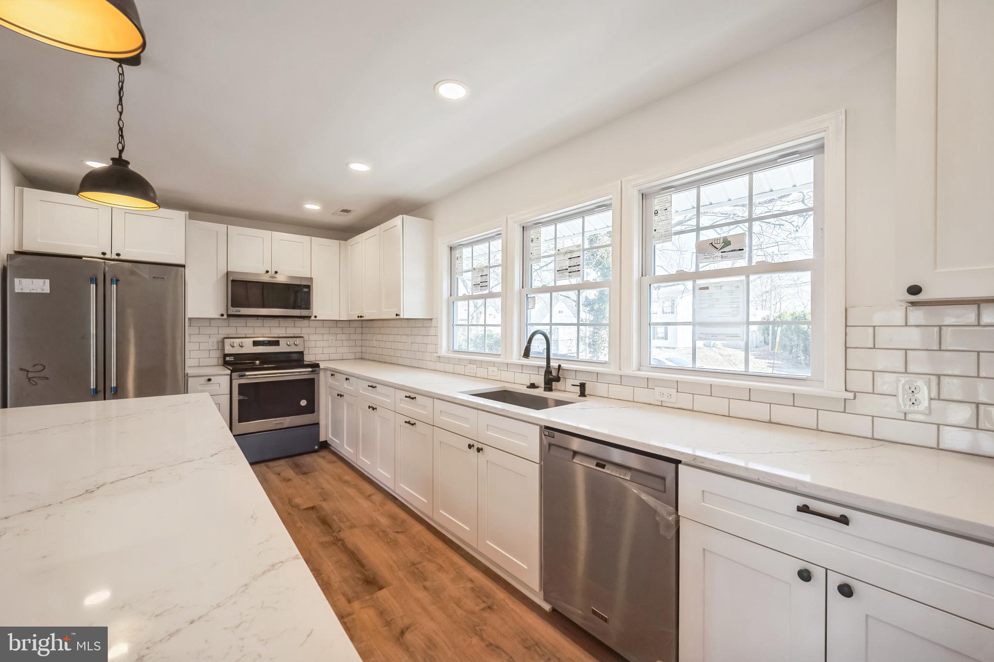 5 River Lane Levittown, PA 19055 - Photo 23 of 35 a kitchen with stainless steel appliances granite countertop a sink a stove a refrigerator cabinets and a window