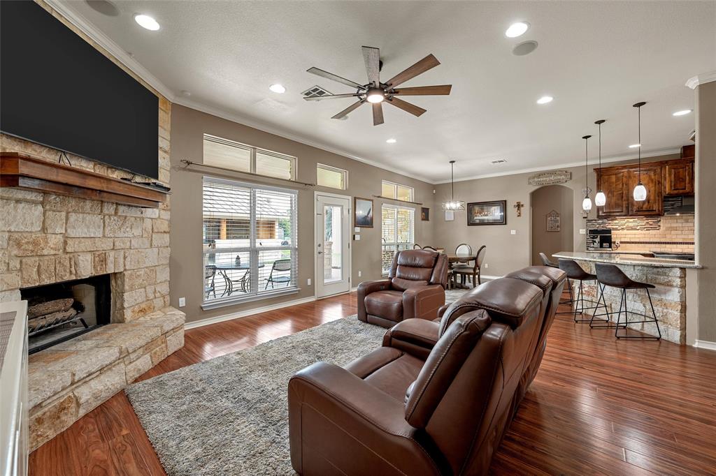 1117 Downsville Road Robinson, TX 76706 - Photo 9 of 40 Spacious living area featuring a stone fireplace with a wood mantle, wood-finish flooring, a ceiling fan, and recessed lighting