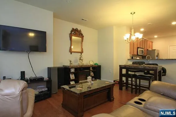 a living room with furniture a flat screen tv and kitchen view