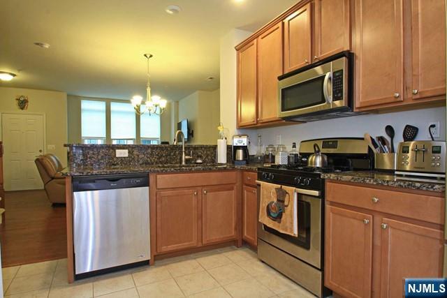 22 Clover Lane Garfield, NJ 07026 - Photo 3 of 17 a kitchen with stainless steel appliances granite countertop a stove a sink and a microwave
