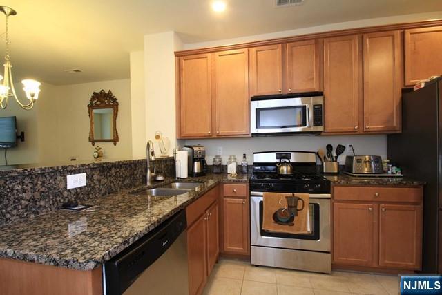22 Clover Lane Garfield, NJ 07026 - Photo 5 of 17 a kitchen with stainless steel appliances granite countertop a stove a sink and a microwave