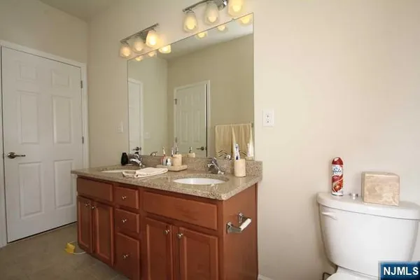 a bathroom with a granite countertop sink a toilet and a mirror