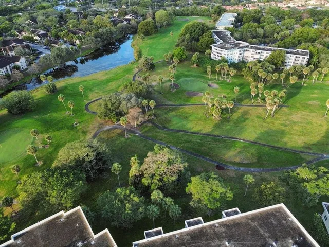 an aerial view of residential houses with outdoor space and trees