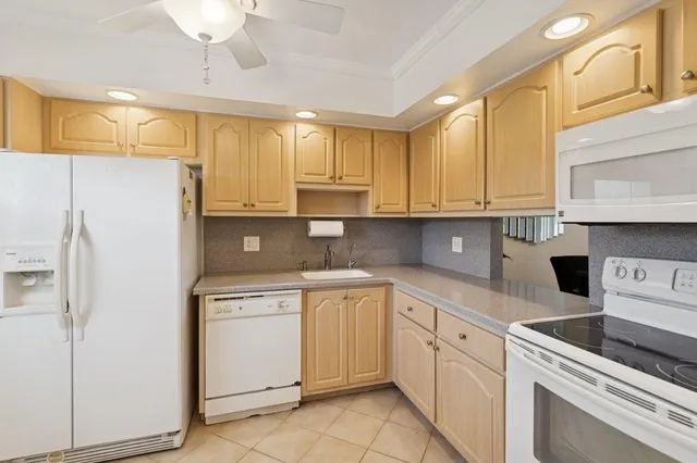 a kitchen with a sink a refrigerator a window and cabinets