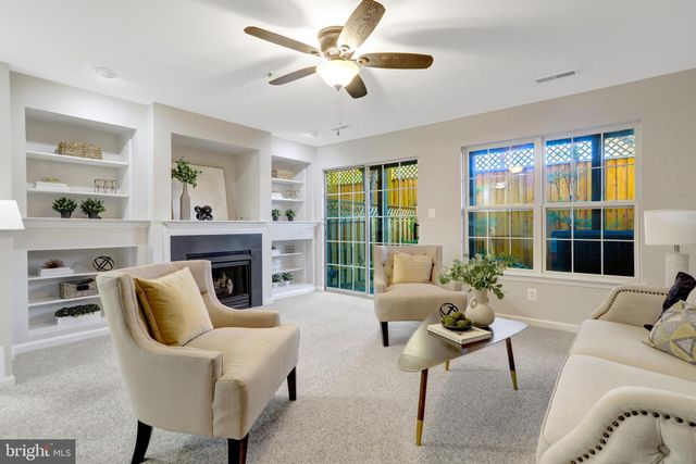 a living room with furniture a fireplace and a large window