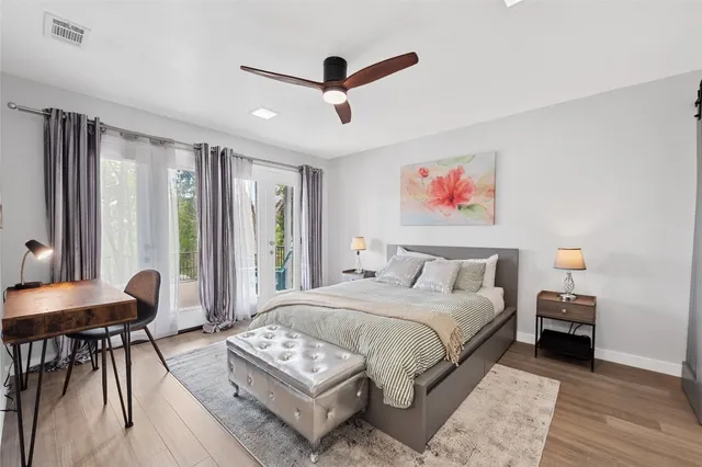 a spacious bedroom with a bed a table and a chandelier