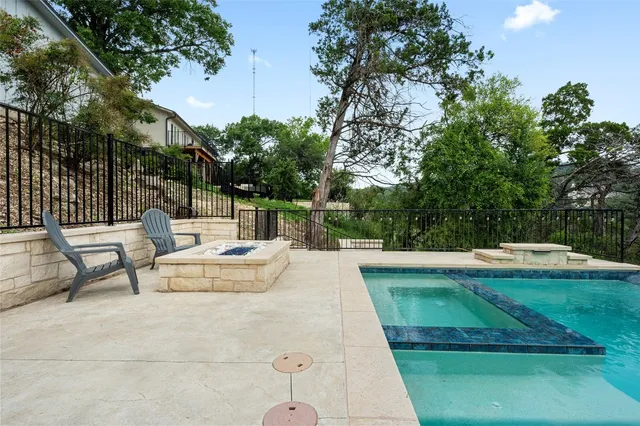 a view of backyard with swimming pool and seating space