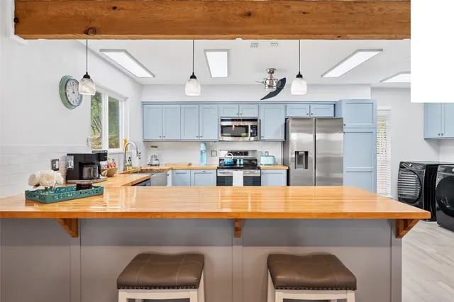 a kitchen with kitchen island a sink stainless steel appliances and cabinets
