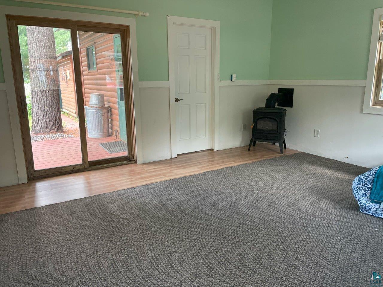 3420 Dewees Road Babbitt, MN 55706 - Photo 28 of 58 Sliding doors offers direct access to the outdoors & the freestanding propane fireplace offers an alternative heat source.