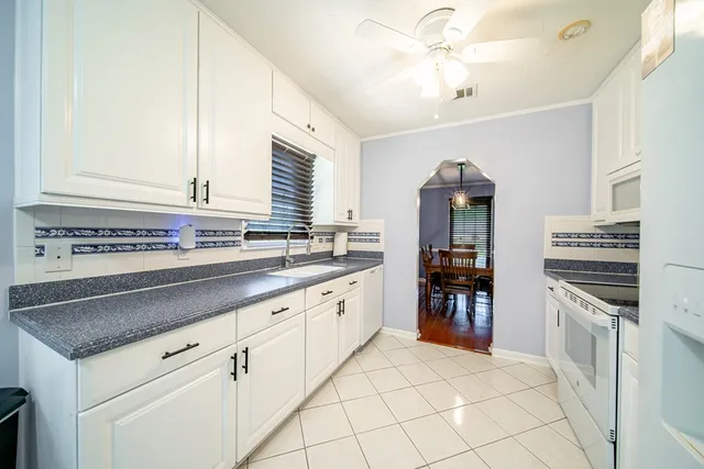 a kitchen with granite countertop a sink stainless steel appliances and cabinets