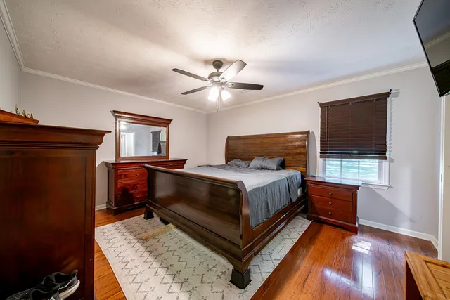 a bedroom with a bed and wooden floor