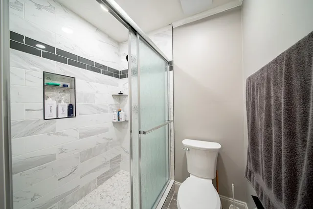 a bathroom with a toilet and a shower
