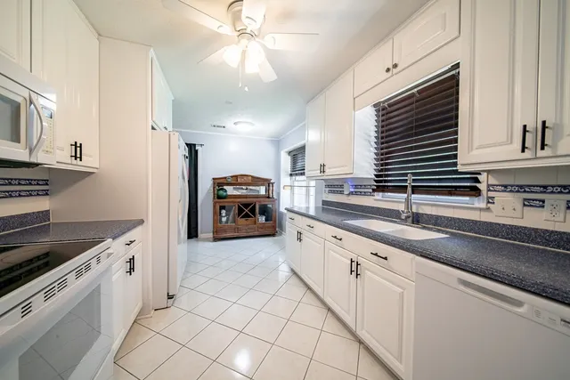 a kitchen with granite countertop a sink cabinets stainless steel appliances and a counter space
