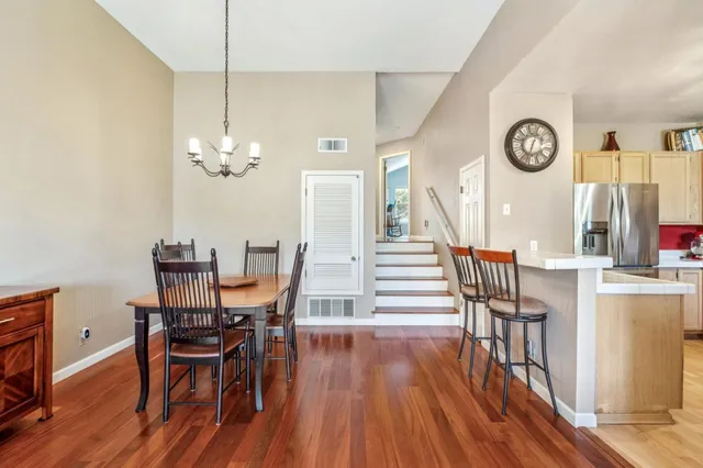 a view of a dining room with furniture a chandelier and wooden floor