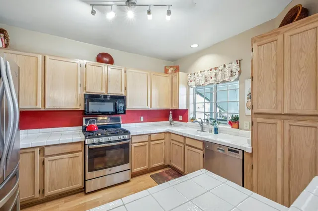 a kitchen with stainless steel appliances a sink stove and cabinets