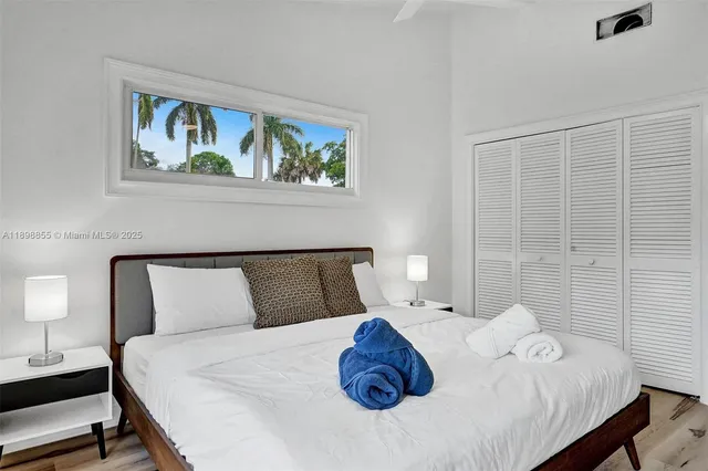a view of a brick house with a small yard and large trees