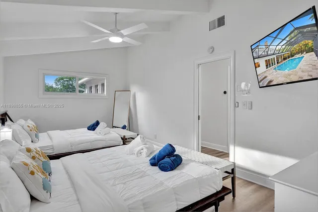 a view of a white house with a yard and potted plants