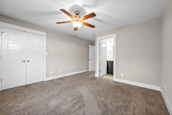 an empty room with ceiling fan and window