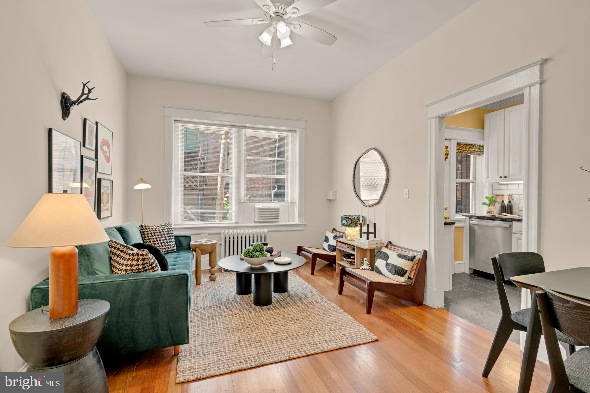 a living room with furniture a lamp and a large window