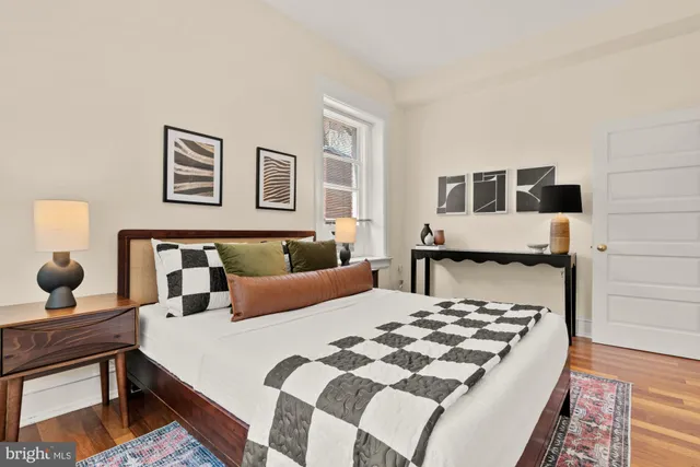 a bedroom with a bed lamp and a window