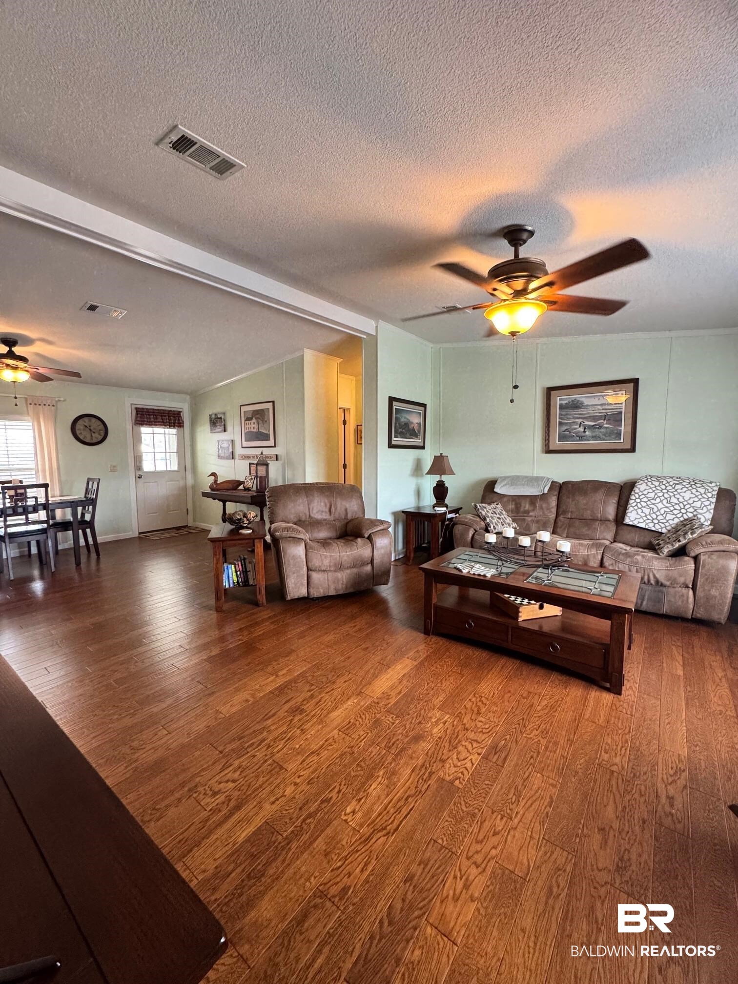 1165 Santa Anna Lane Lillian, AL 36549 - Photo 9 of 43 Living area featuring a ceiling fan, visible vents, a textured ceiling, and wood finished floors