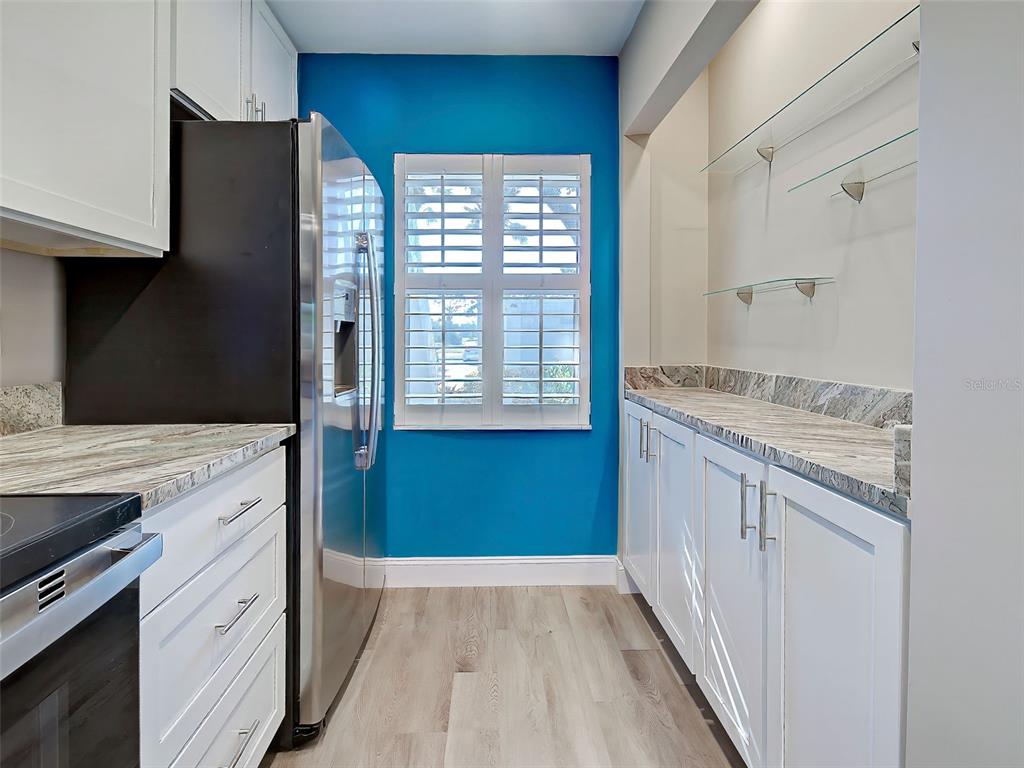 429 Cerromar Lane, Unit 352 Venice, FL 34293 - Photo 12 of 47 a kitchen with granite countertop a refrigerator and a sink