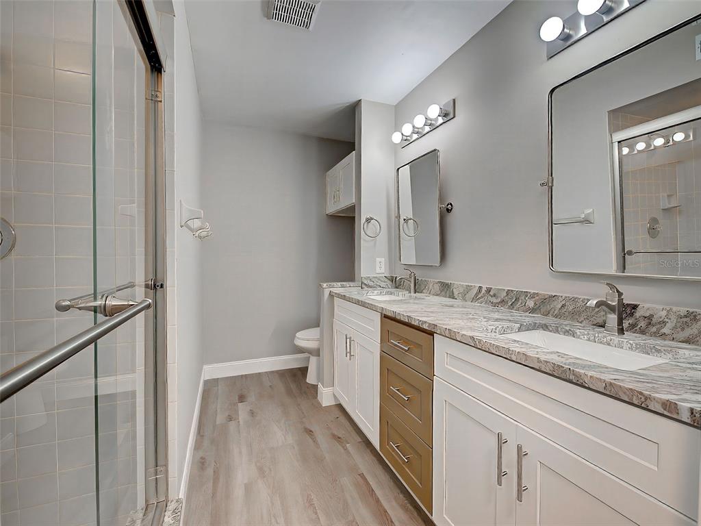 429 Cerromar Lane, Unit 352 Venice, FL 34293 - Photo 25 of 47 a bathroom with a granite countertop sink mirror and a toilet