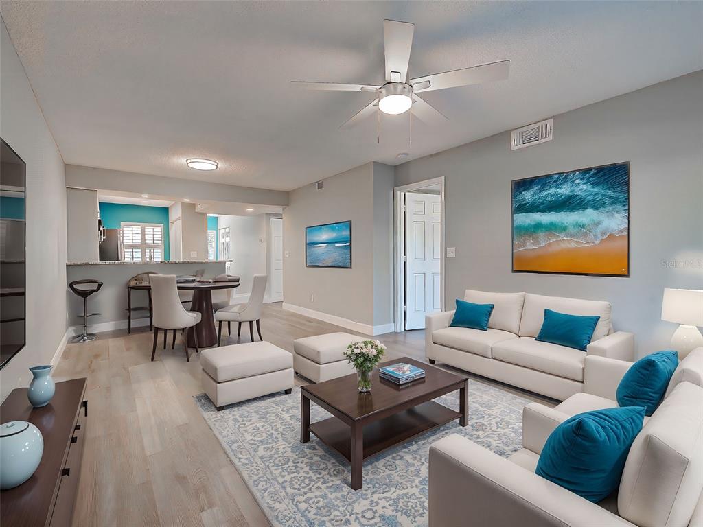 429 Cerromar Lane, Unit 352 Venice, FL 34293 - Photo 8 of 47 a living room with furniture and a wooden floor