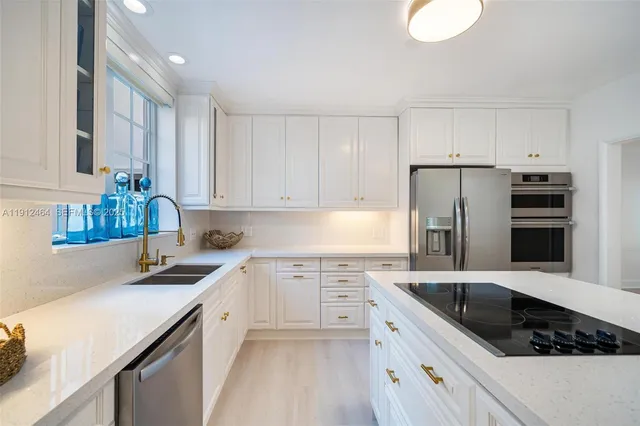 a kitchen that has a sink cabinets counter space and stainless steel appliances