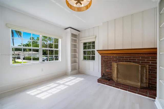 a view of an empty room with a fireplace and window