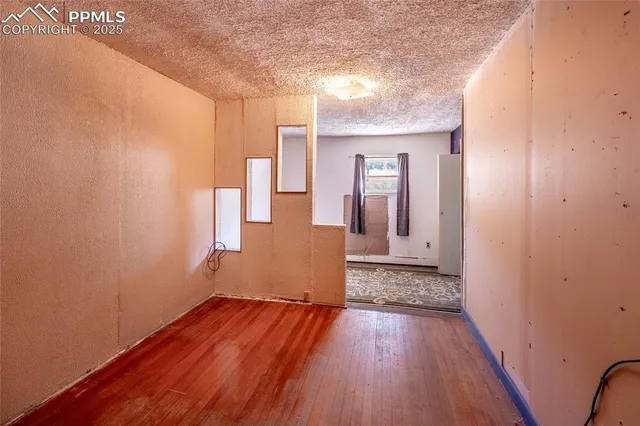a view of a room with wooden floor and a window