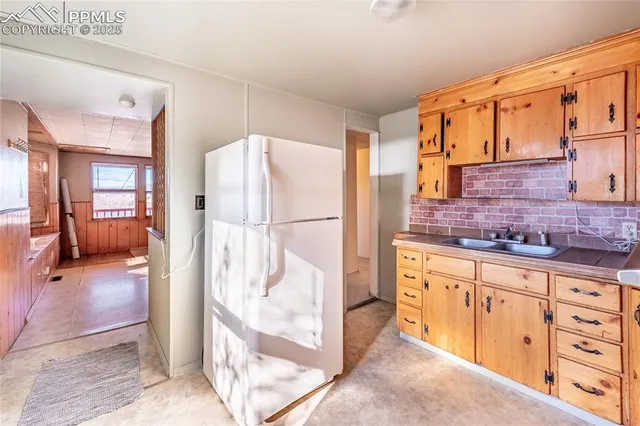 a kitchen with granite countertop a refrigerator and a sink