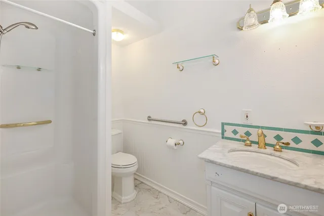 a bathroom with a granite countertop sink a toilet and a mirror