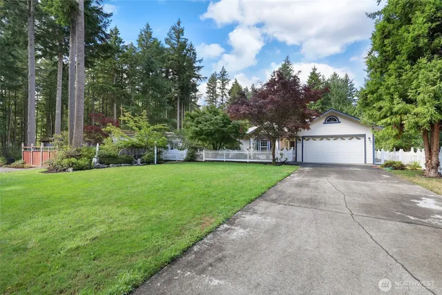 a front view of a house with a garden and trees