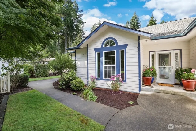 a front view of a house with a yard and potted plants