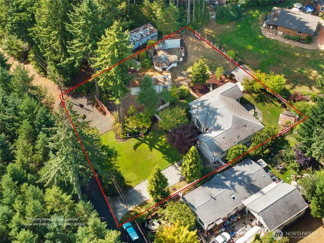 an aerial view of residential house with outdoor space and trees all around