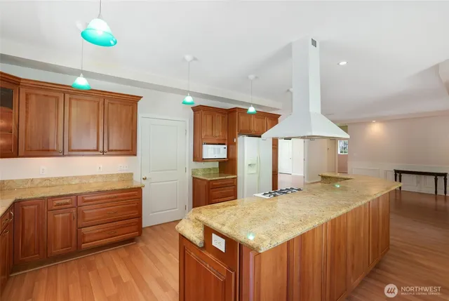 a kitchen with a stove a refrigerator a sink and dishwasher with wooden floor