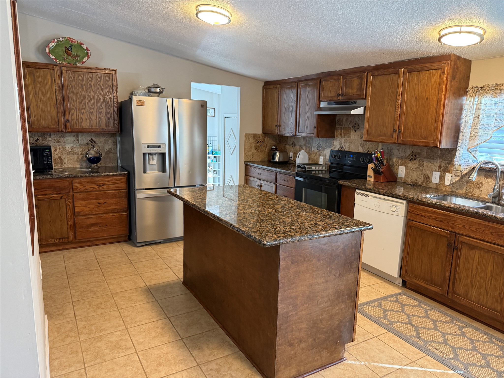 7538 Rocky Ridge Lane Madisonville, TX 77864 - Photo 13 of 48 a kitchen with stainless steel appliances granite countertop a stove a refrigerator and a sink