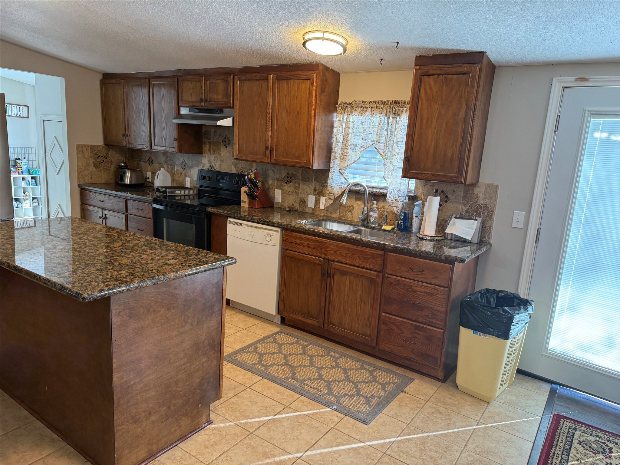 7538 Rocky Ridge Lane Madisonville, TX 77864 - Photo 21 of 47 Spacious kitchen featuring elegant granite countertops, rich wood cabinetry, and modern appliances, perfect for culinary enthusiasts.