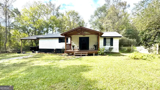 a front view of a house with a yard and trees