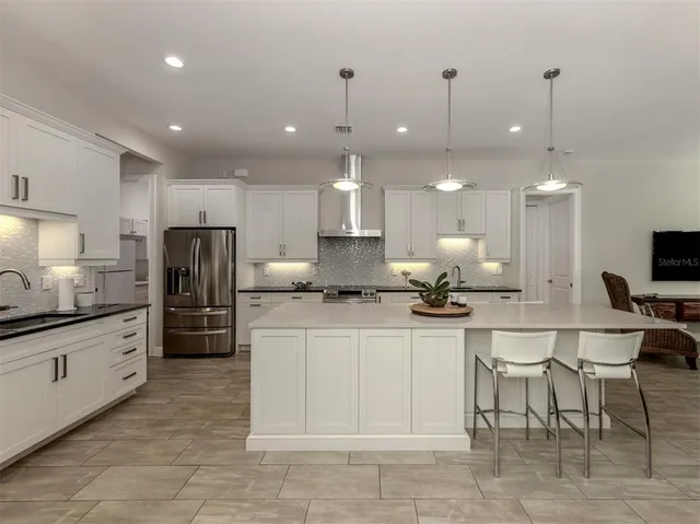 a kitchen with stainless steel appliances kitchen island granite countertop a sink and cabinets