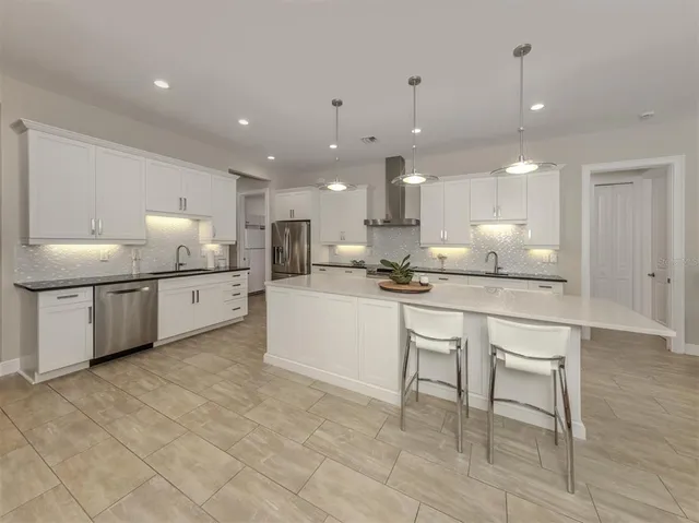 a kitchen with kitchen island granite countertop a sink and white cabinets