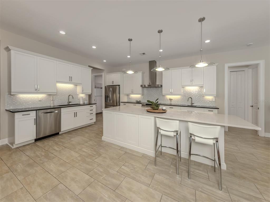 332 Pensacola Road Venice, FL 34285 - Photo 12 of 56 a kitchen with kitchen island granite countertop a sink and white cabinets