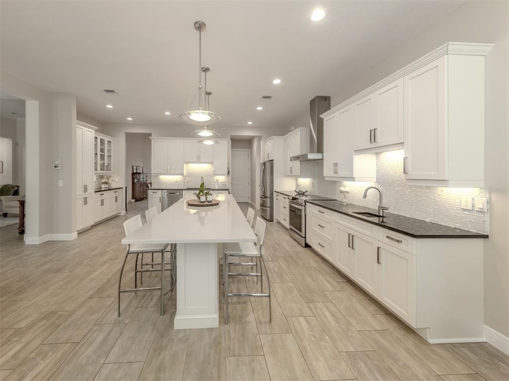 332 Pensacola Road Venice, FL 34285 - Photo 13 of 56 a kitchen with stainless steel appliances kitchen island granite countertop a sink a stove and a wooden floors