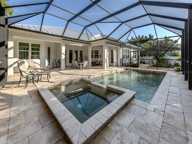 a view of a house with backyard sitting area and swimming pool